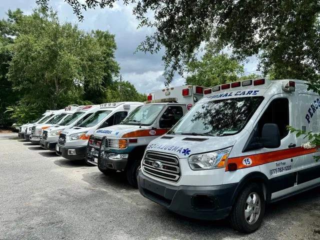 A row of ambulances parked in a parking lot.