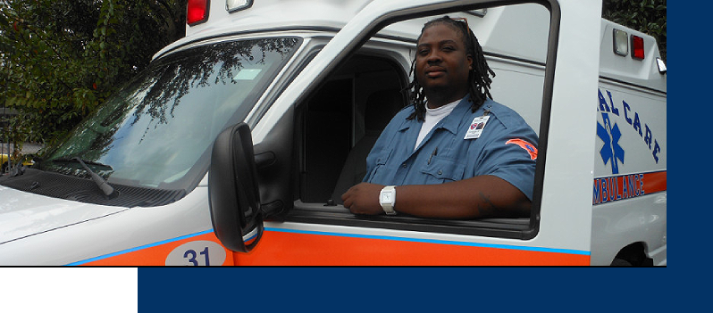 A man sitting in the drivers seat of an ambulance.